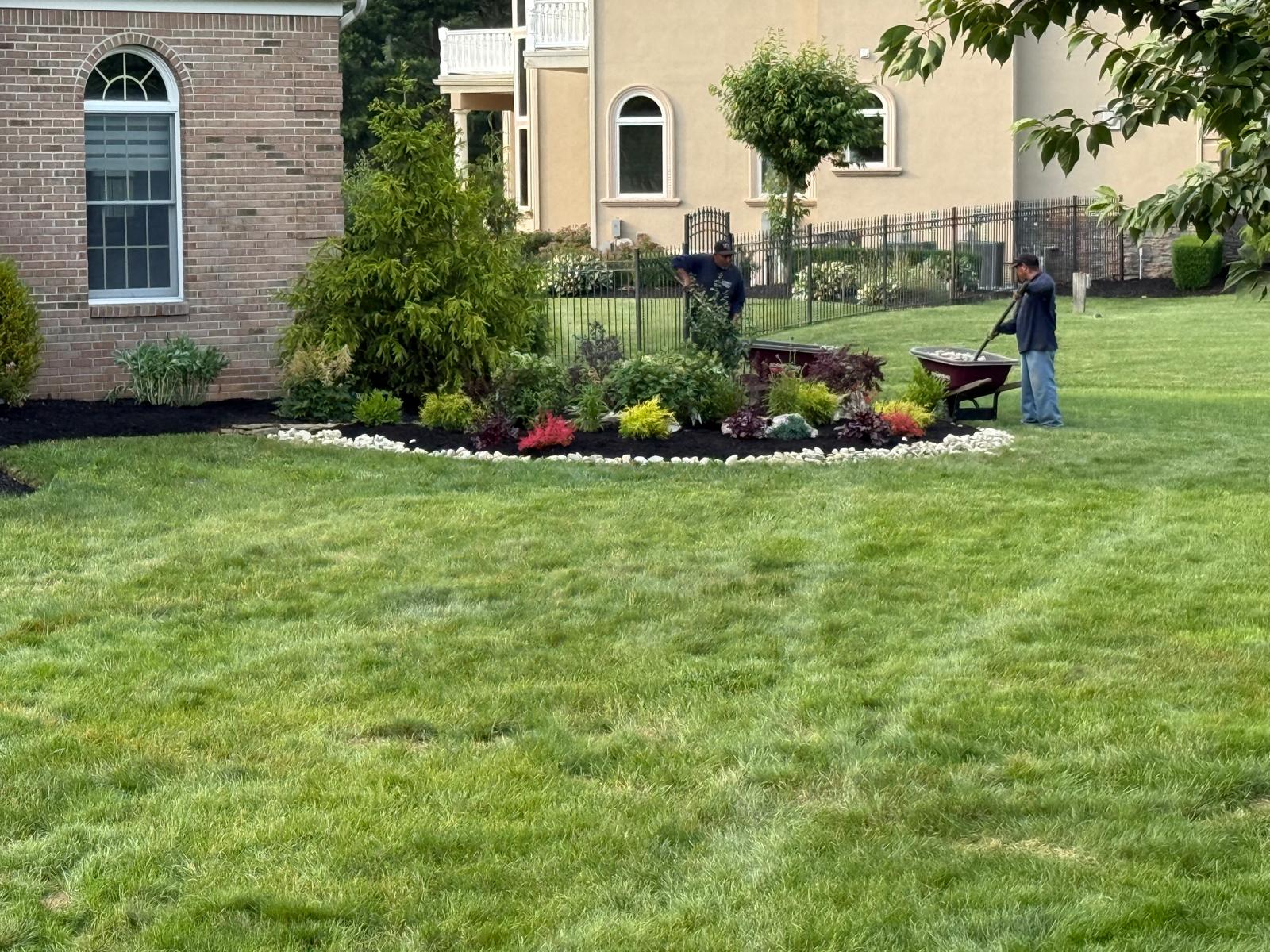 David's Landscaping crew installing a planting bed at dusk